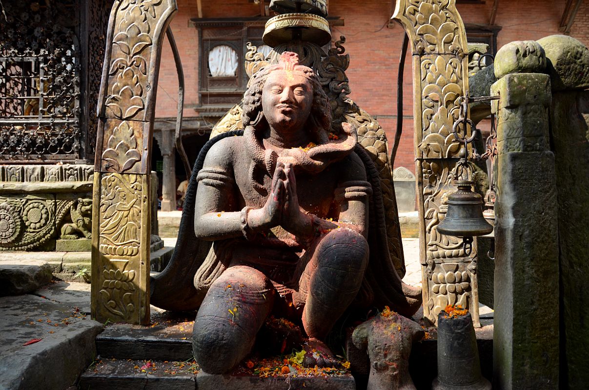 Kathmandu Changu Narayan 21 5C Life Size Garuda Statue Kneels In Front Of Main Entrance To Changu Narayan Temple Facing the main entrance to the Changu Narayan Temple is a life size 5C statue of a kneeling Garuda, the carrier of Lord Vishnu, with a snake around his neck and his hands together saying Namaste.